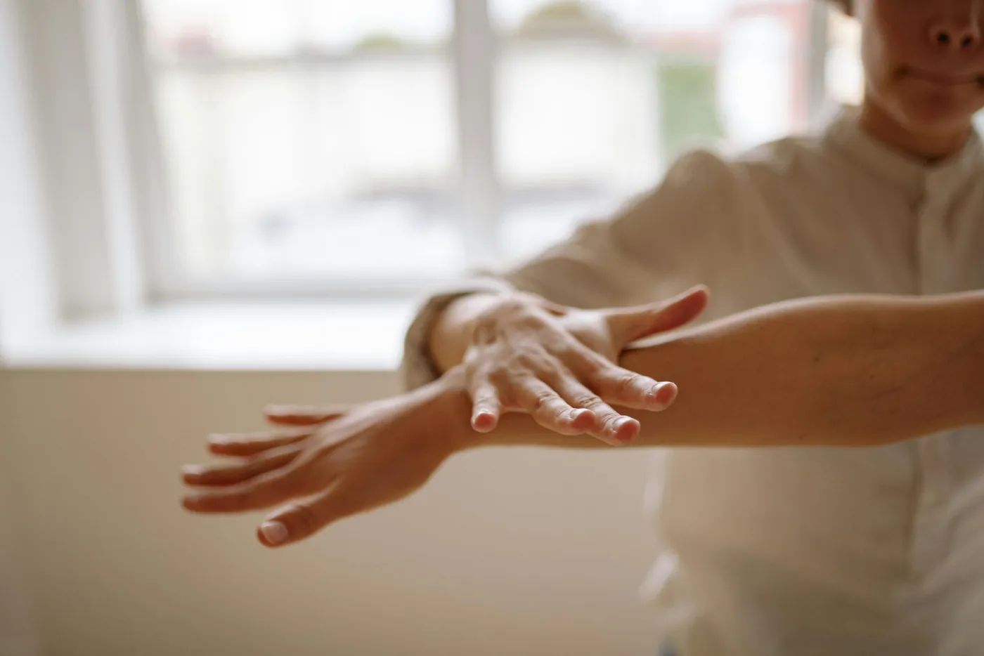 Test musculaire de kinésiologie : la praticienne appuie doucement sur le bras tendu d'une consultante